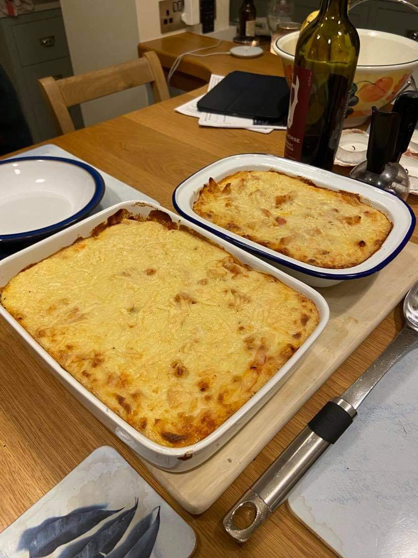 Two dishes of cooked Lasagne on a table 